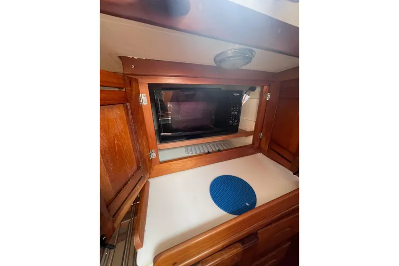 Slide: The Image of 2002 Tartan 37 yacht interior with microwave and wooden cabinetry. - 19