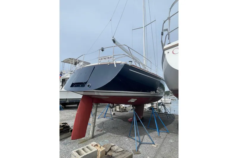 Slide: The Image of Tartan 37 sailboat from 2002 on stands, displayed in a marina setting. - 2