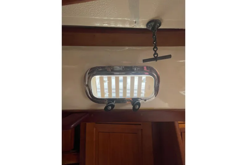 Slide: The Image of Portlight window inside a 2002 Tartan 37 sailboat, featuring wooden interior details. - 20