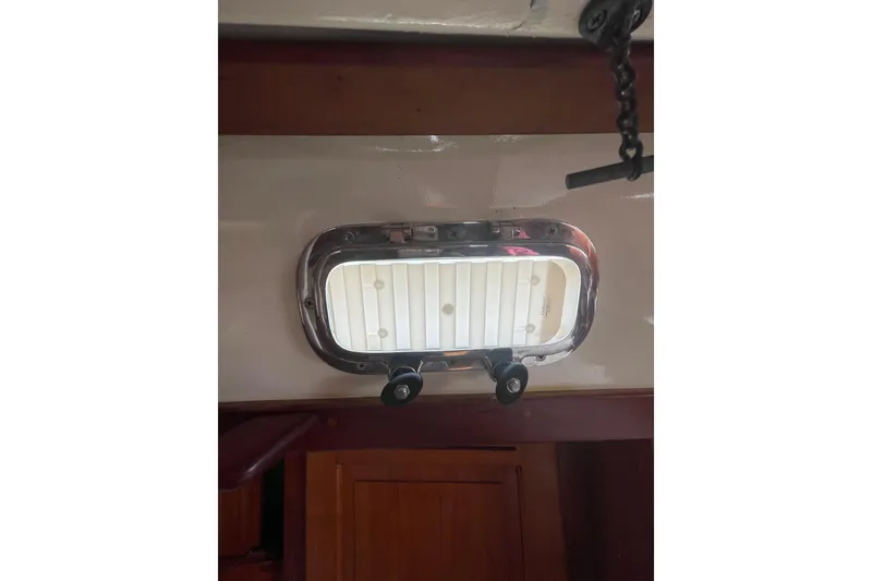 Slide: The Image of Portlight window inside a 2002 Tartan 37 sailboat, featuring a polished metal frame. - 21