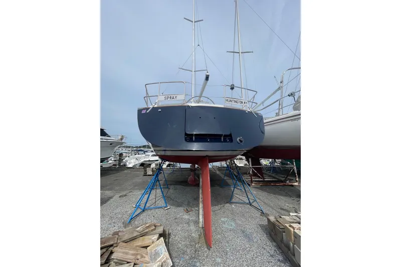 Slide: The Image of Tartan 37 sailboat from 2002 on stands, rear view, in a boatyard. - 3