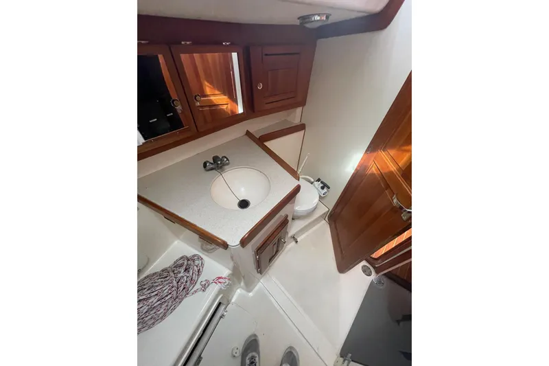 Slide: The Image of Bathroom interior of a 2002 Tartan 37 yacht with wooden cabinets and white fixtures. - 8