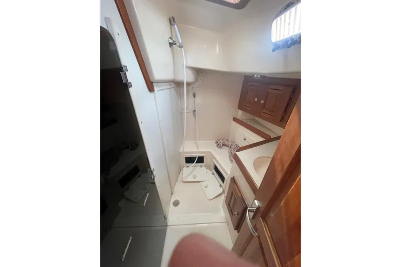 Slide: The Image of 2002 Tartan 37 yacht bathroom with shower, sink, and wooden cabinets. - 9