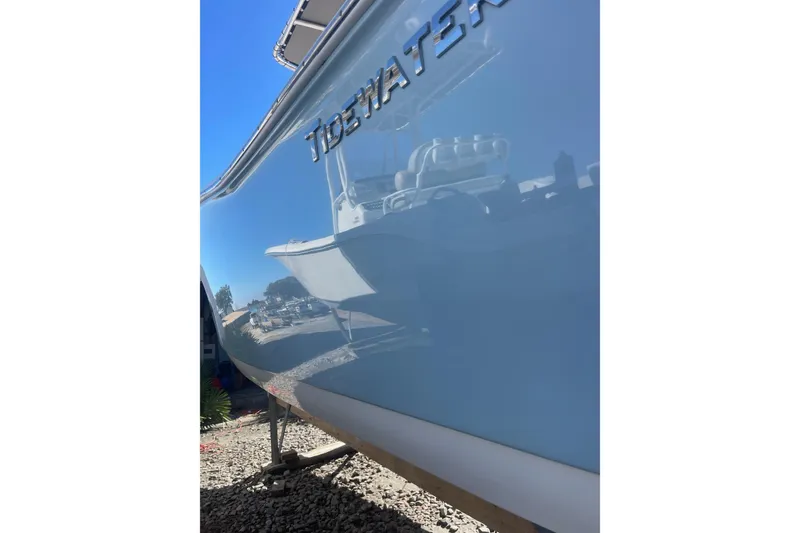 Slide: The Image of 2017 Tidewater 220 CC Adventure boat reflecting surroundings, showcasing sleek design and craftsmanship. - 18