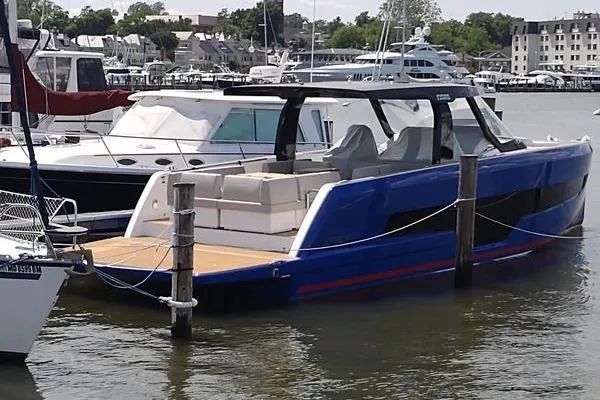 Slide: The Image of 2023 Fjord 41 XL luxury yacht docked in marina, featuring sleek blue design and spacious deck. - 13