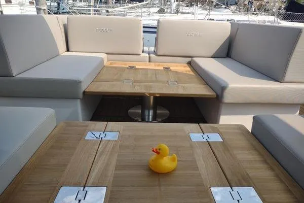 Slide: The Image of 2023 Fjord 41 XL yacht interior with wooden tables and a rubber duck. - 18