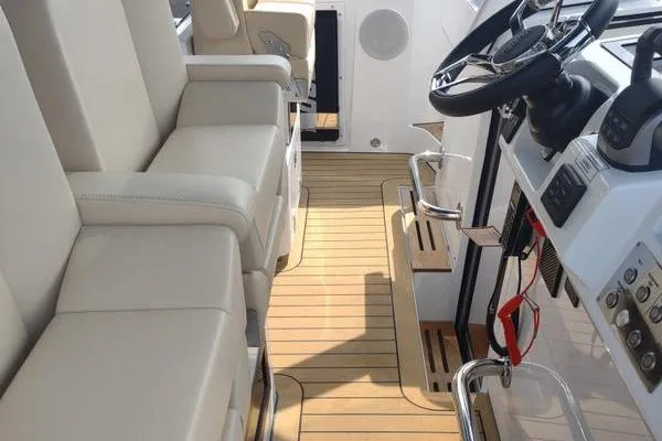 Slide: The Image of 2023 Fjord 41 XL yacht interior with beige seating and modern steering console. - 29