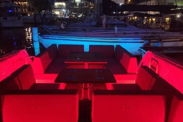 Slide: The Image of 2023 Fjord 41 XL yacht interior with vibrant red lighting at night. - 43