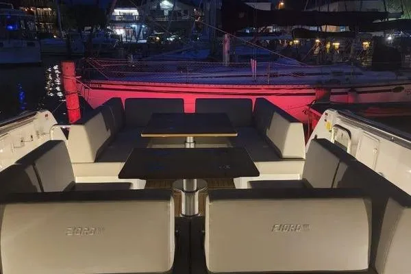 Slide: The Image of Luxurious 2023 Fjord 41 XL yacht interior with elegant seating and tables, docked at night. - 44