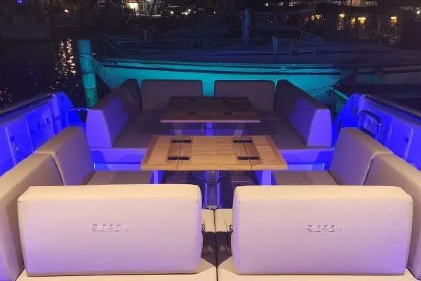 Slide: The Image of 2023 Fjord 41 XL yacht interior with elegant seating and ambient blue lighting. - 45