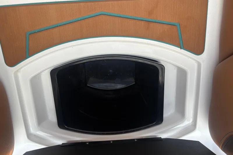 Slide: The Image of 2026 Malibu Wakesetter 21 LX interior storage compartment with wood accents. - 14