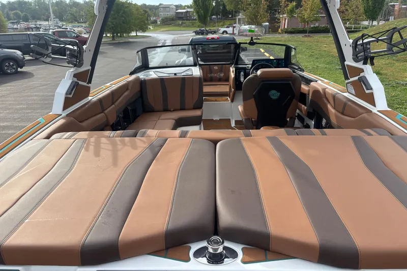 Slide: The Image of 2026 Malibu Wakesetter 21 LX interior with brown and gray seating, parked outdoors. - 4