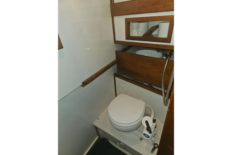 Slide: The Image of 1978 CHB 34 boat bathroom with toilet, sink, and wooden accents. - 21