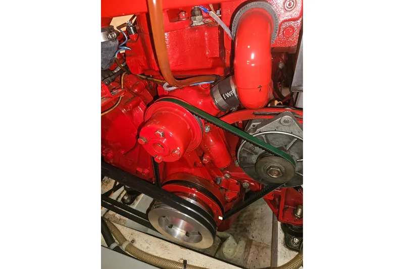 Slide: The Image of Red engine of a 1978 CHB 34 boat, featuring belts and hoses. - 26