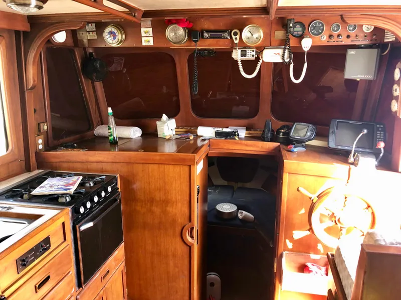 Slide: The Image of 1978 CHB 34 boat interior with wooden deck and blue canopy in storage. - 3