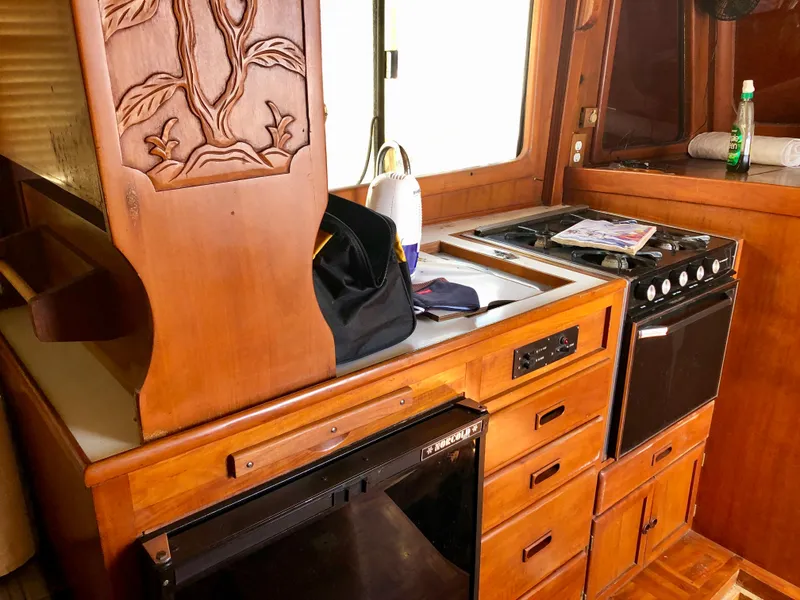 Slide: The Image of 1978 CHB 34 boat interior with wooden deck and white seating under a wooden roof. - 4