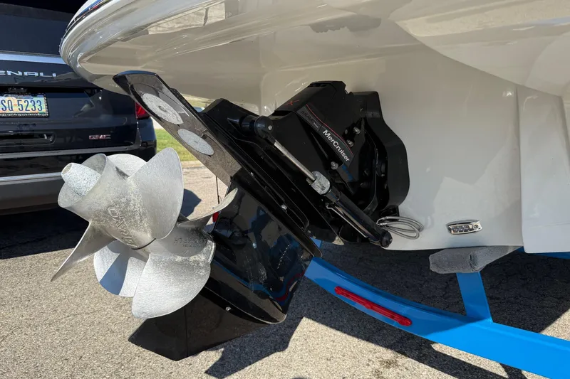 Slide: The Image of 2023 Crownline 290 SS boat with MerCruiser outdrive and propeller, parked on a trailer. - 13