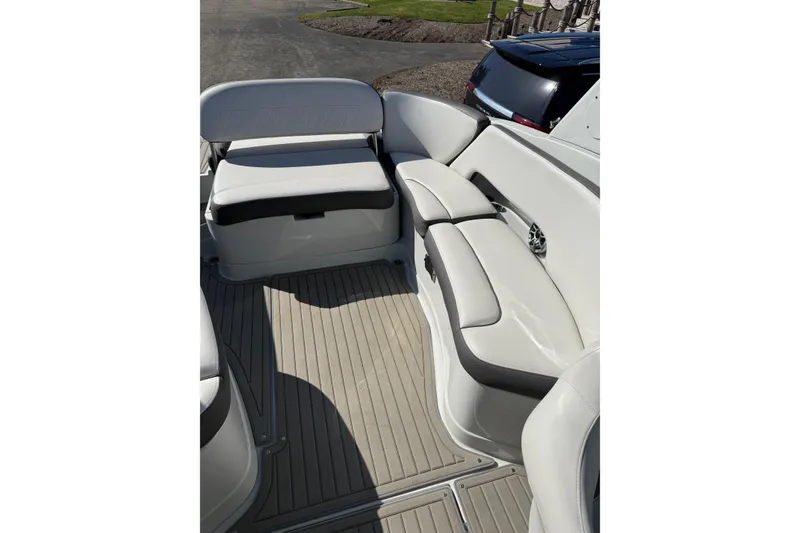 Slide: The Image of 2023 Crownline 290 SS boat interior with white seating and gray flooring. - 7