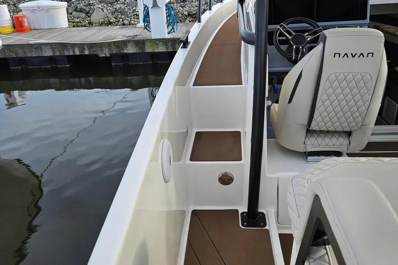 Slide: The Image of 2025 Navan S30 boat deck with cushioned seating and cup holder by the water. - 13