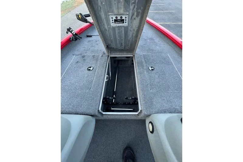 Slide: The Image of 2016 Tracker Pro Team 175 TXW boat with open storage compartment on carpeted deck. - 24