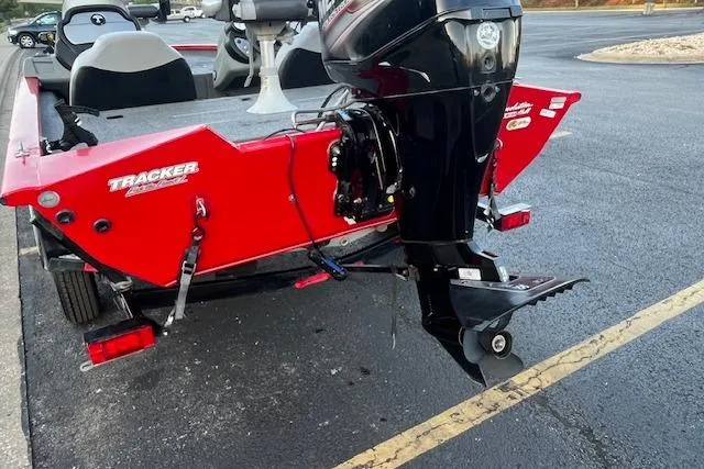 Slide: The Image of 2016 Tracker Pro Team 175 TXW boat with 60 HP motor, parked near a river. - 8