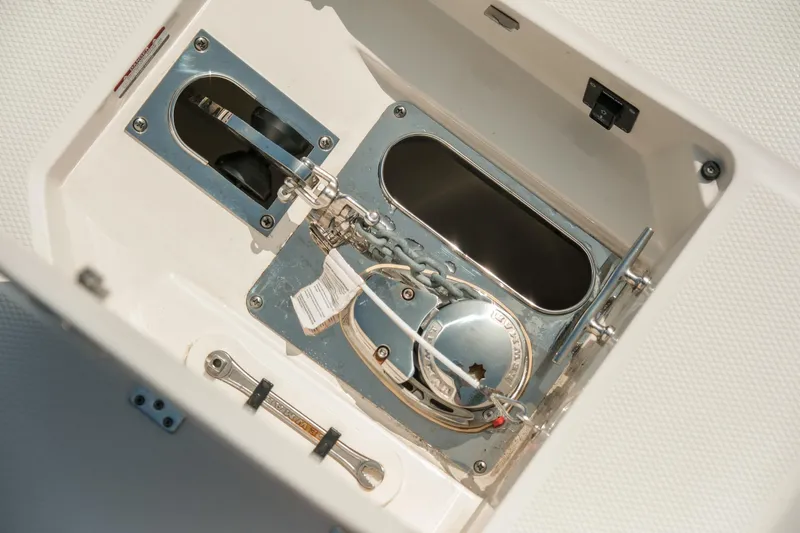 Slide: The Image of 2023 Robalo R270 Center Console boat anchor compartment with metal fittings. - 27