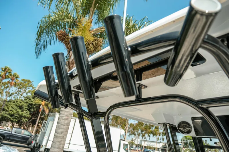 Slide: The Image of 2023 Robalo R270 Center Console boat with rod holders, palm trees in background. - 32