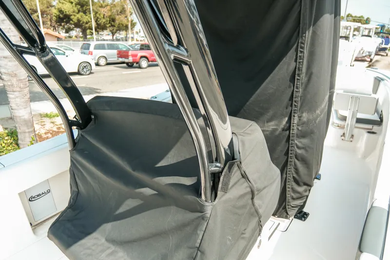 Slide: The Image of 2023 Robalo R270 Center Console boat with protective covers, parked outdoors. - 37