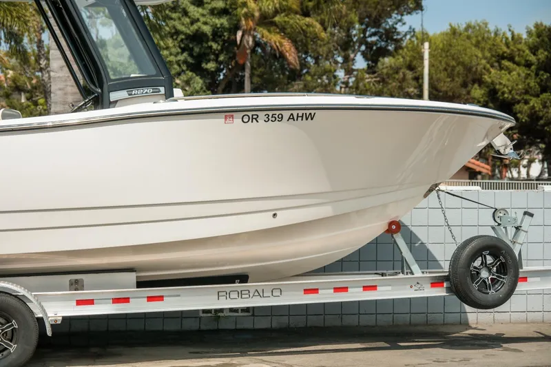 Slide: The Image of 2023 Robalo R270 Center Console boat on trailer, side view, outdoors. - 4