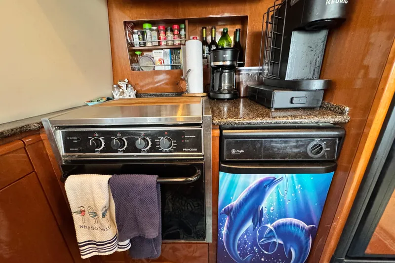Slide: The Image of Compact kitchen in 2006 Meridian 490 Pilothouse with stove, coffee maker, and dolphin-themed mini fridge. - 15