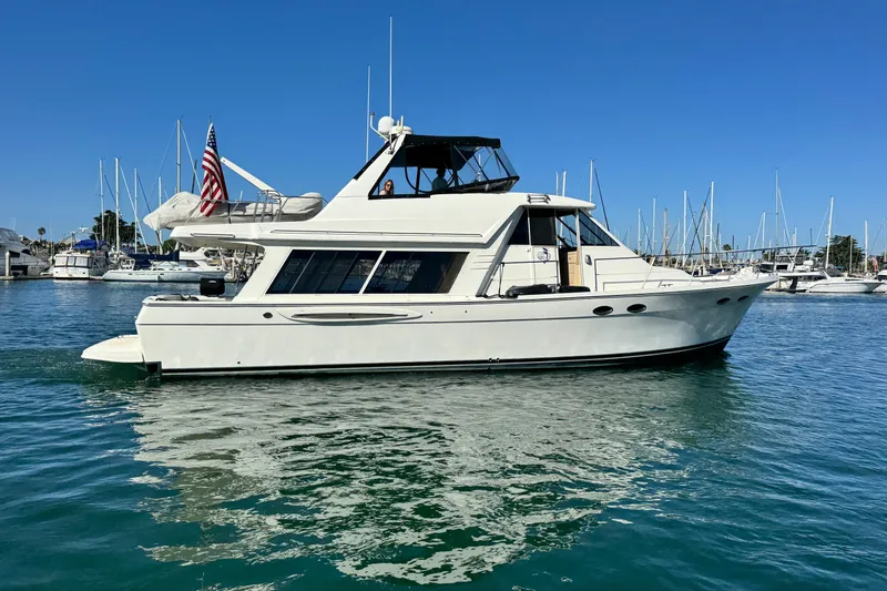 Slide: The Image of 2006 Meridian 490 Pilothouse yacht docked in marina, clear blue sky background. - 2