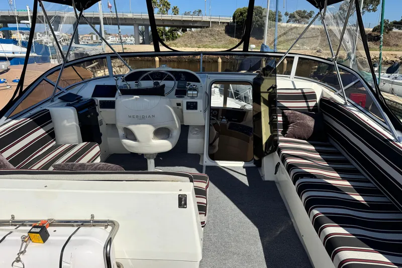 Slide: The Image of 2006 Meridian 490 Pilothouse interior with striped seating and helm station. - 27