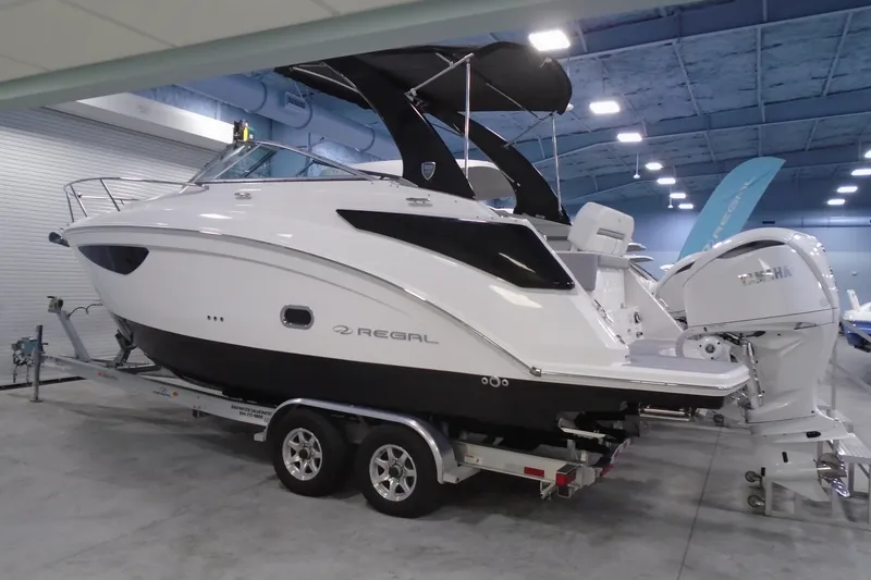 Slide: The Image of 2026 Regal 26 XO boat on trailer in indoor showroom. - 1