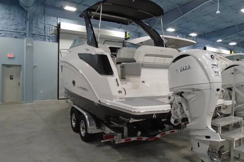 Slide: The Image of 2026 Regal 26 XO boat with Yamaha outboard engine in indoor showroom. - 2