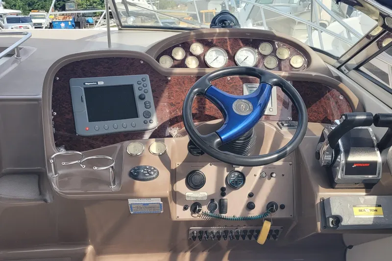 Slide: The Image of 2005 Regal Commodore 3560 IO boat dashboard with steering wheel and control panel. - 12