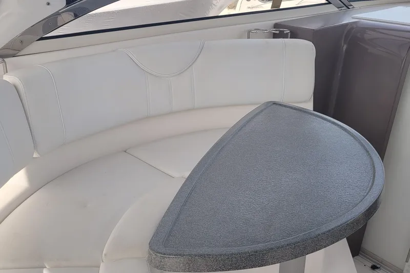 Slide: The Image of 2005 Regal Commodore 3560 IO boat interior with white seating and a gray table. - 20