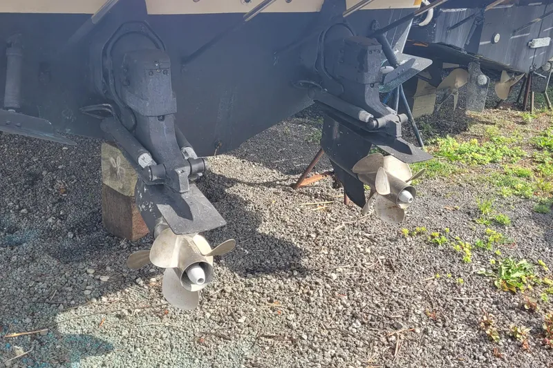 Slide: The Image of 2005 Regal Commodore 3560 IO boat propellers on gravel surface. - 26