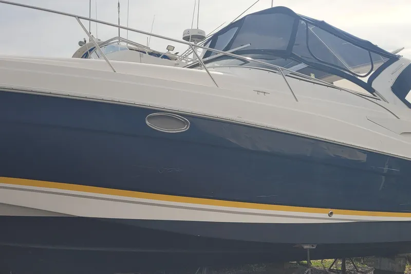 Slide: The Image of 2005 Regal Commodore 3560 IO boat with blue and white exterior, docked. - 5