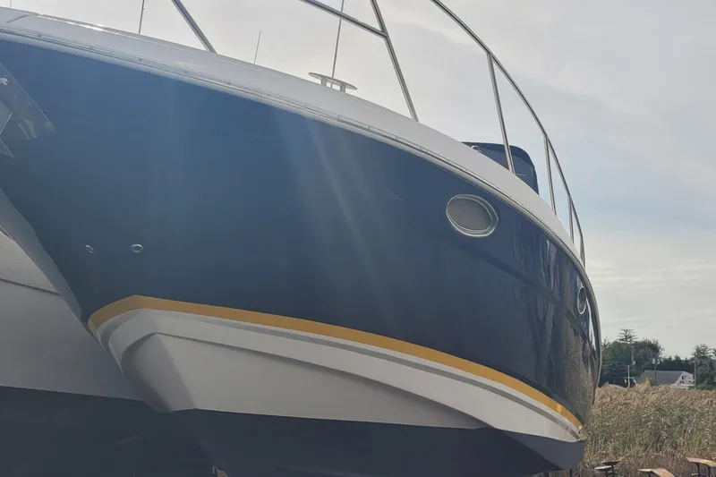 Slide: The Image of 2005 Regal Commodore 3560 IO boat with sleek blue hull and yellow stripe. - 6