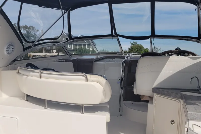 Slide: The Image of 2005 Regal Commodore 3560 IO boat interior with seating and helm, under clear blue sky. - 7