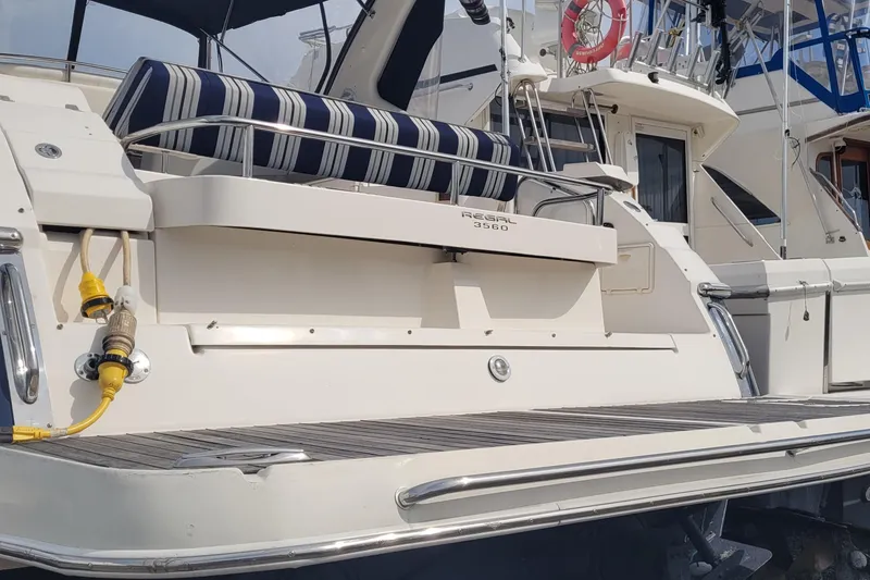 Slide: The Image of 2005 Regal Commodore 3560 IO yacht with striped seating and dock connections. - 9