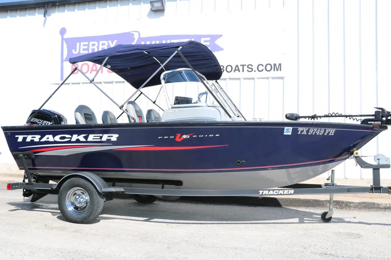 The Image of 2019 Tracker Pro Guide V-16 WT boat on trailer, parked outside dealership. - 1