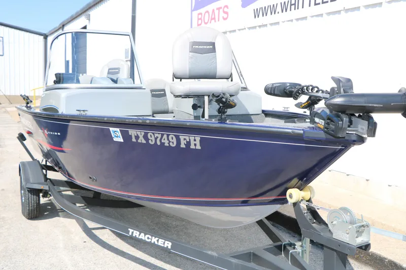 Slide: The Image of 2019 Tracker Pro Guide V-16 WT boat on trailer, blue exterior, parked outdoors. - 7