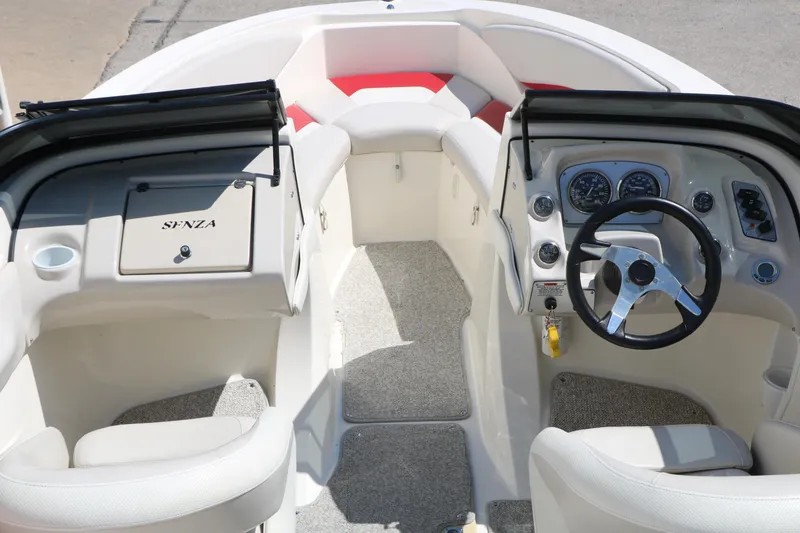 Slide: The Image of Interior view of a 2006 Larson 206 Senza boat, featuring steering wheel and dashboard controls. - 13