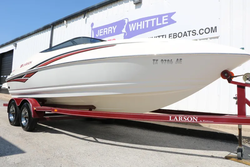 Slide: The Image of 2006 Larson 206 Senza boat on red trailer outside dealership. - 30