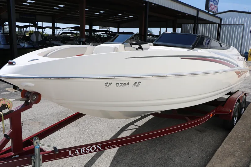 Slide: The Image of 2006 Larson 206 Senza boat on trailer, parked in a covered area. - 6