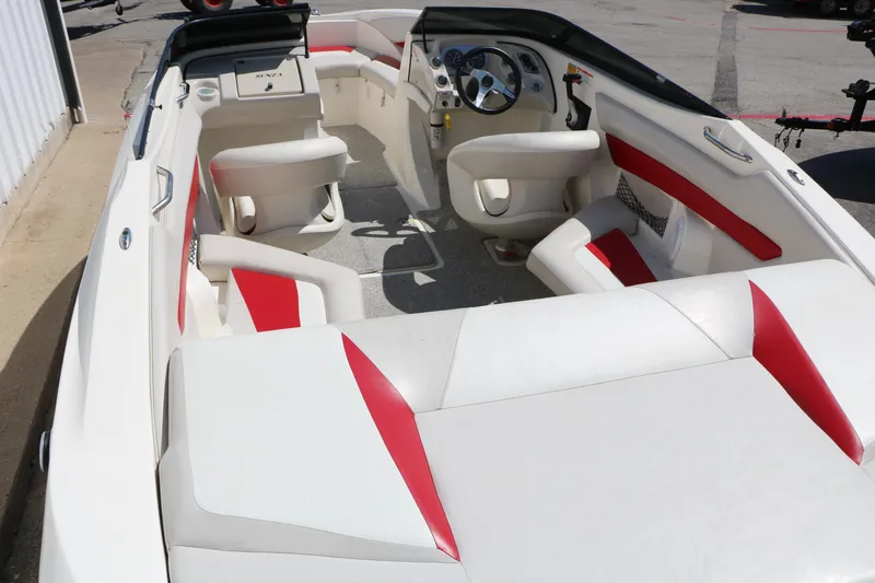 Slide: The Image of 2006 Larson 206 Senza boat interior with white and red seating, steering wheel, and dashboard. - 9