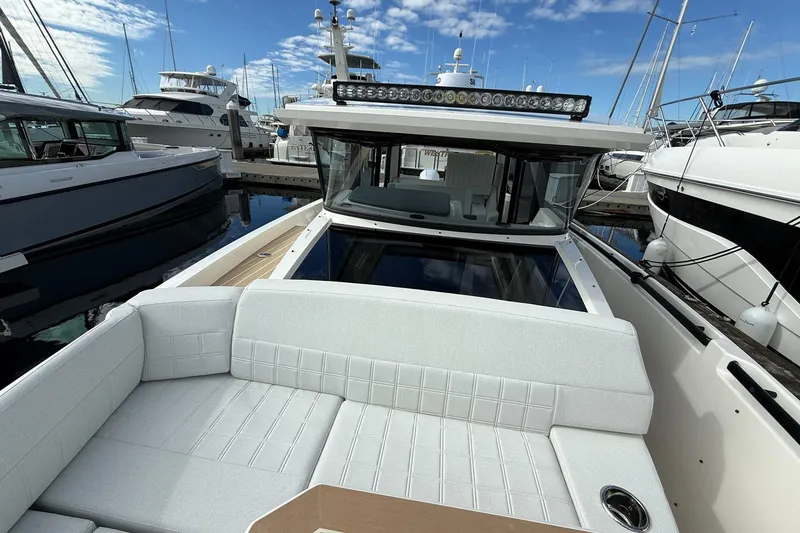 Slide: The Image of 2026 Saxdor 340 GTWA boat with sleek design and modern seating at a marina. - 19