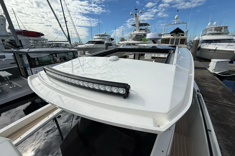 Slide: The Image of 2026 Saxdor 340 GTWA boat with sleek design, docked at marina under blue sky. - 20