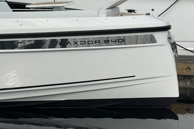 Slide: The Image of 2026 Saxdor 340 GTWA boat docked at marina, surrounded by other luxury yachts. - 4